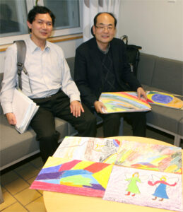 Varapresidentti Takayuki Yoshioka ja presidentti Yoshihiro Kitamura esittelivät Feeling Arts esityksen synnyttämiä lasten piirroksia.
